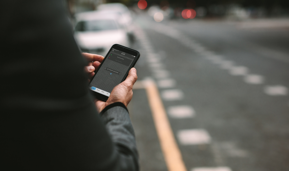 Photo of A Man Using Ride-Sharing App